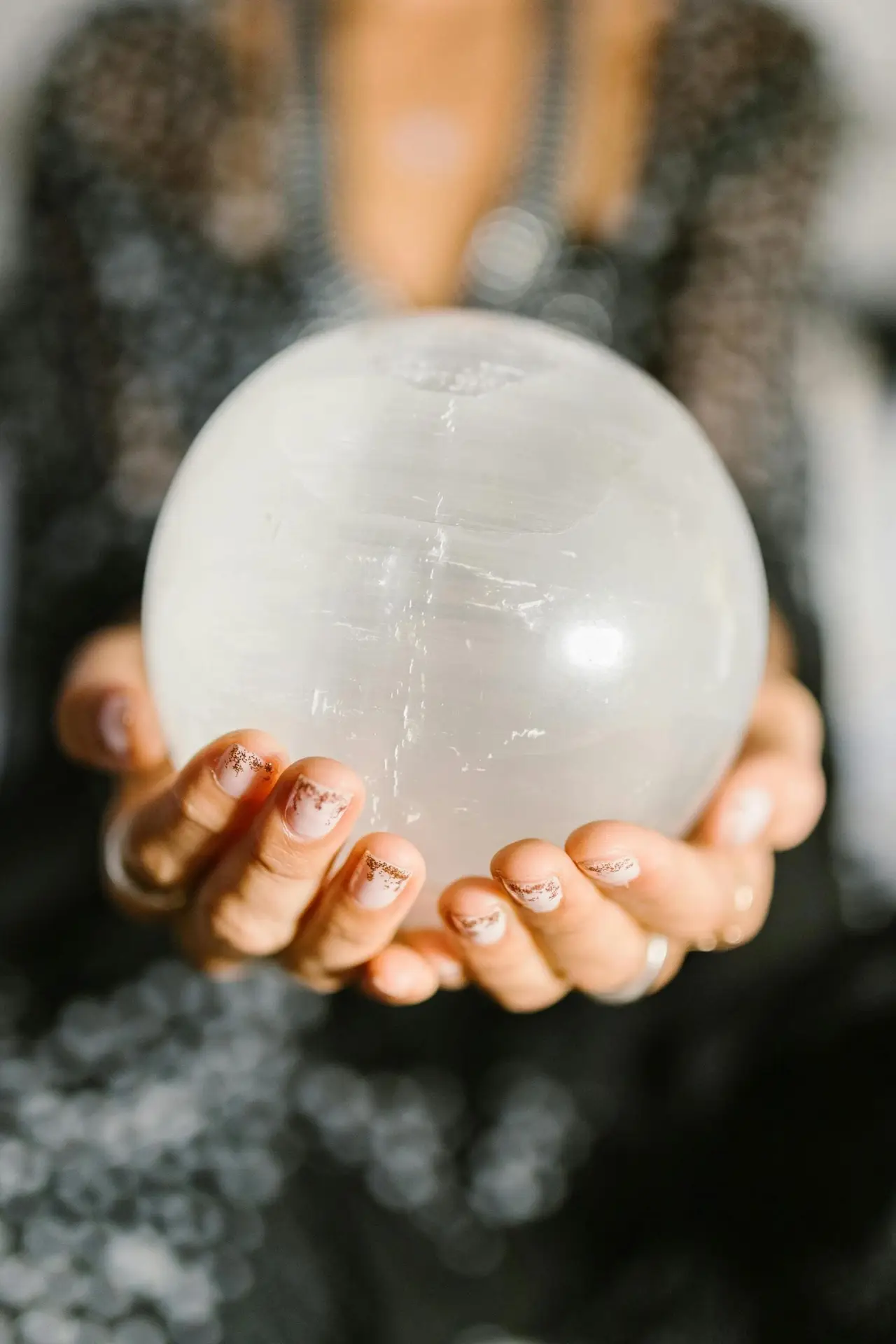 Boule de cristal entre des mains de voyante.